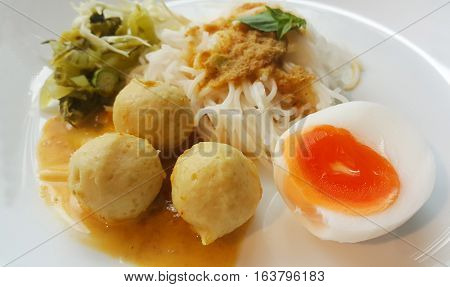 Vermicelli solution (Noodles) and fish curry coconut milk with vegetable on white background.(Kanom Jeen Nam Ya)