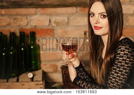 Woman Tasting Wine In Rural Cottage Interior