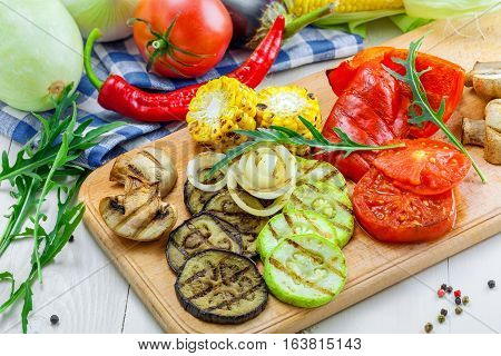 Grilled vegetables: tomato corn eggplant mushroom bell pepper marrow and onion. Delicious healthy food and ingredients on a table.