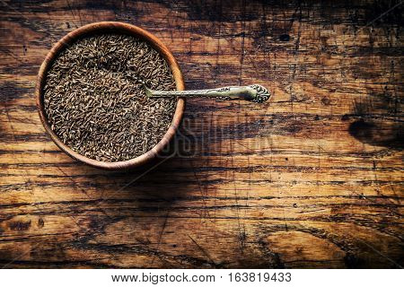 Cumin.Caraway seeds on wooden table. Cumin in vintage bronze bowl and spoon.