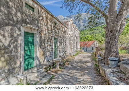 Typical house in Tucepi old village in the slope of a mountain Biokovo. Tree shadow texture on the facade.