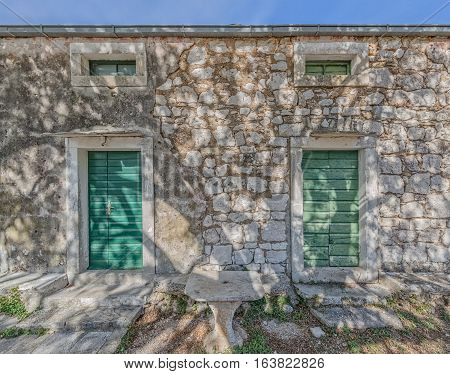 Typical house in Tucepi old village in the slope of a mountain Biokovo. Tree shadow texture on the facade.