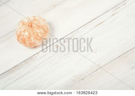 Slices of tangerine (mandarin) on old white wooden background. Closeup