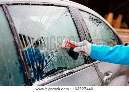 Woman Deicing Side Car Windshield With Scraper