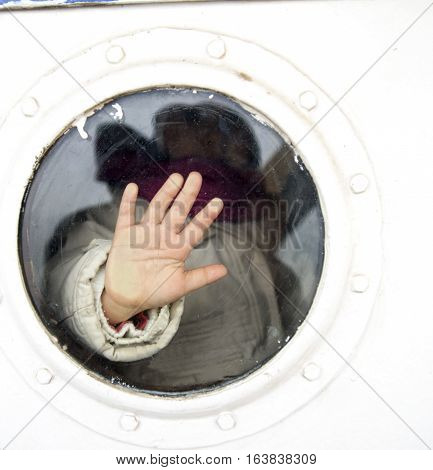 photo of child hand on a ship vindow