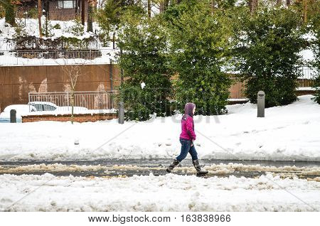 Charlottesville, USA - March 6, 2013: Woman walking on snow covered street after storm on University of Virginia campus