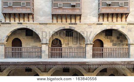 Front view of three arches with interleaved wooden balustrades at the arcade surrounding the courtyard of caravansary (Wikala) of Bazaraa, Medieval Cairo, Egypt