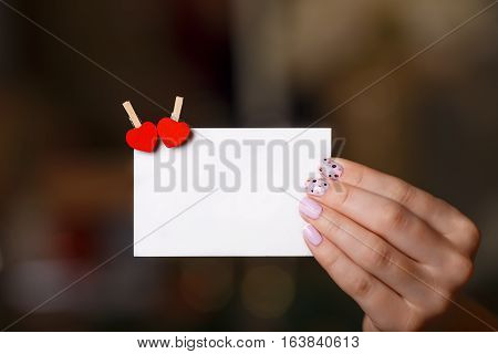 woman hand holds paper cart with two heart pins