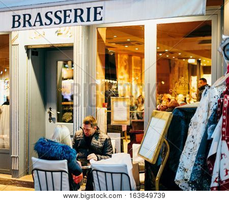 STRASBOURG FRANCE - DEC 20 2016: Couple enjoying coffee on outdoor cafe in the iconic brasserie of the Maison Kammerzell in Strasbourg