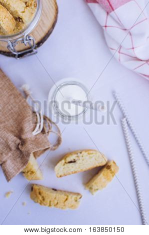 Homemade raisins cookies with bottle of milk on white background. Freshly baked raisin cookie. Healthy breakfast raisins cookies and milk. Tasty cookies for an afternoon snack. Top view.