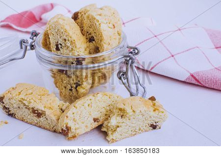 Homemade raisins cookies on white background. Jar with freshly baked raisin cookie. Healthy breakfast raisins cookies. Tasty cookies for an afternoon snack. Selective Focus.