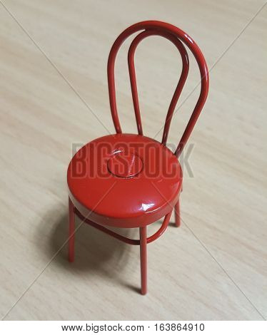 Red Metal Toy Chair on Wooden Table