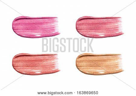 Different lip glosses isolated on white. Smudged lip gloss sample