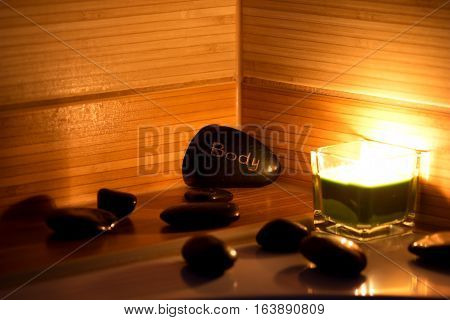 black lava stones massage and a green candle