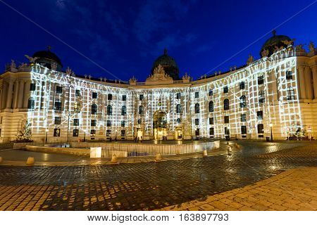 Famous hofburg palace in vienna at night with lights, seen from michaelerplatz, austria