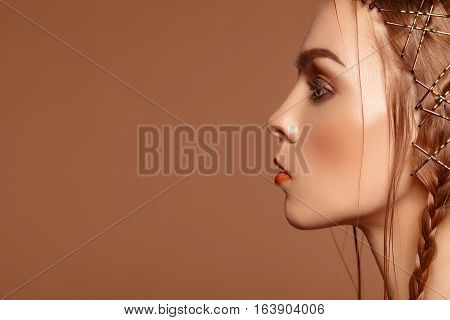 Beauty portrait charm of a beautiful girl with red hair and freckles. Hair in a pigtail. Bright makeup.
