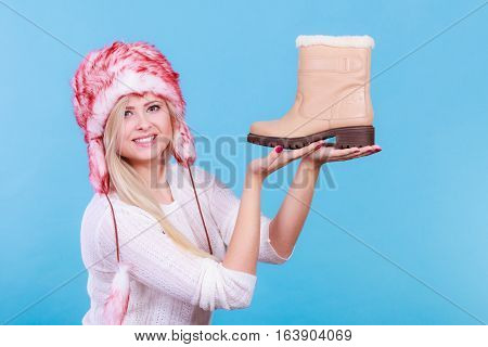 Woman In Furry Winter Hat Holding Beige Boots