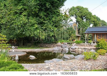 SAINT-PETERSBURG, RUSSIA, AUGUST 3, 2016: Fragment of The Japanese Garden with tea house and pond in Peter the Great Botanical Garden (Botanic Gardens of the Komarov Botanical Institute)