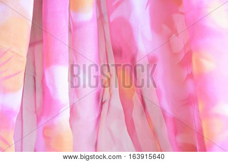 Photo by pink chiffon with vertical gathers to background.