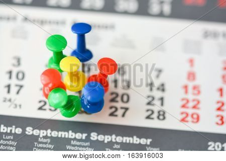 Multiple pins on a calendar suggesting busy day or schedule