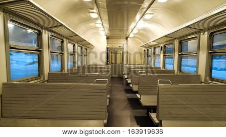 The interior of a passenger train with empty seats