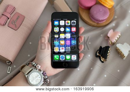 Alushta Russia - November 11 2016: Woman hand with Watch holding iPhone 7 Jet Black. iPhone 7 was created and developed by the Apple inc.