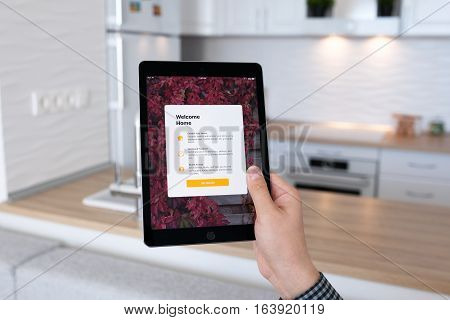 Alushta Russia - October 29 2016: Man hand holding iPad Pro Space Gray with app Home in the screen. iPad Pro 9.7 was created and developed by the Apple inc.