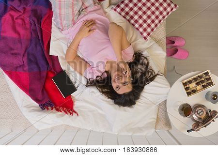 Woman In Bed With Phone