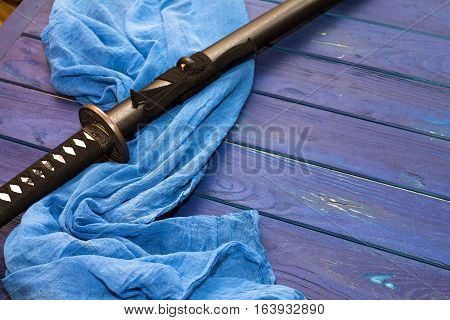 japan katana sword on the wood background with the blue shawl