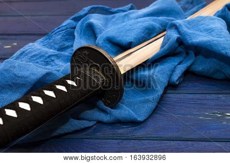japan katana sword on the wood background with the blue shawl
