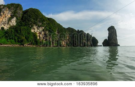 Sea and karst mountains covered with green bushes and trees, landscape of Krabi Province in Thailand.