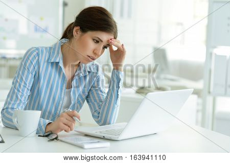 young woman working at office, using laptop