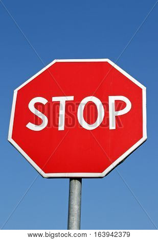Stop roadsign over clear bright blue sky