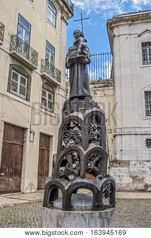Lisbon Portugal. Sculpture in front of Santo Antonio Church bright spring day a beautiful yellow rose on a pedestal.