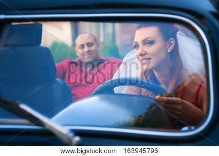 bride and groom in a retro car outdoor