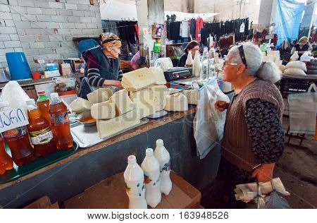 SIGNAGI, GEORGIA - OCT 7, 2016: Older women buying homemade cheese on Georgian village market on October 7, 2016. Signagi of Kakhetia has a population 2.200
