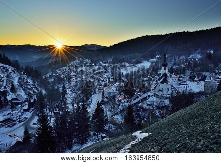 Sunset at winter in Slovakia. Old mining village. Historic church in Spania Dolina.