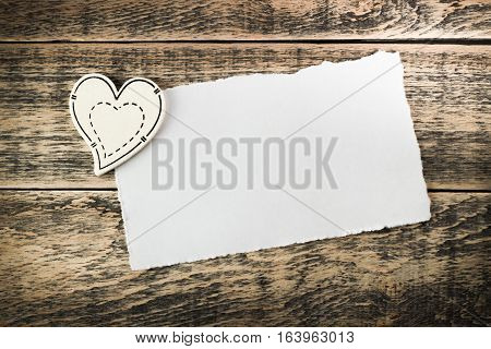 Wooden hearts and a sheet of paper on wooden texture