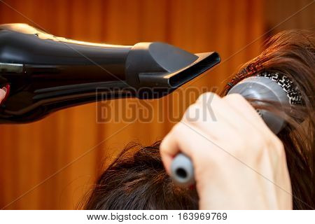 Girl dries hair and makes your hair with a comb