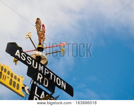 Rooster Weather vane - set against a blue sky and cloud