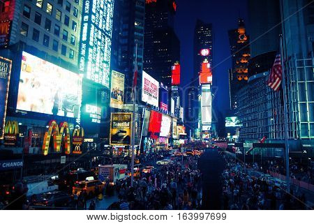 New York, United States - September 13, 2014. Times Square at night, with commercial buildigs, street traffic and people.
