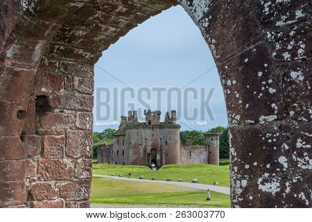 Shearington, Scotland, Uk - June 18, 2012: Ruined Triangular Brown Stone Moated Caerlavarock Castle 