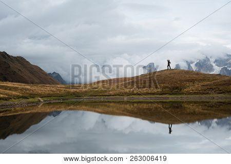 Koruldi - lake in Svaneti, Georgia. Mirror reflection in water. View of the Caucasus Mountains. Autumn landscape. Tourist in the hike