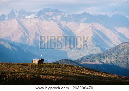 Autumn landscape. Ridge in clouds. Mountain hut in a hillside Mkheer. Caucasus, Zemo Svaneti, Georgia 
