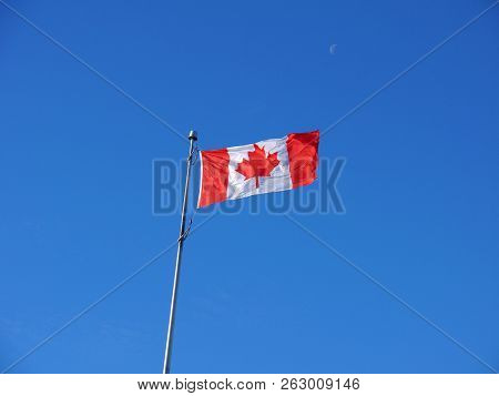 The National Flag Of Canada In Blue Sky