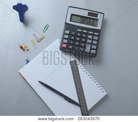 Pen On Notebook And Calculator On Desk