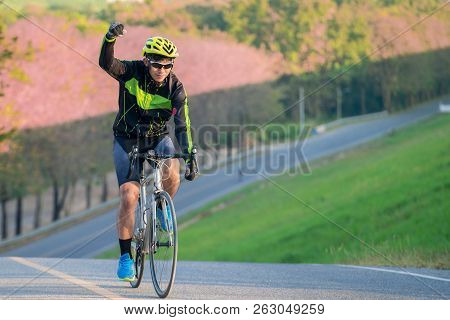 Asian Man Ride A Bicycle On The Road With Nature Background And Finish This Target To Go To Top Of M
