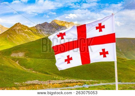 Beautiful View To Waving Flag Of Georgia On The Georgian Military Road Against The Background Of The