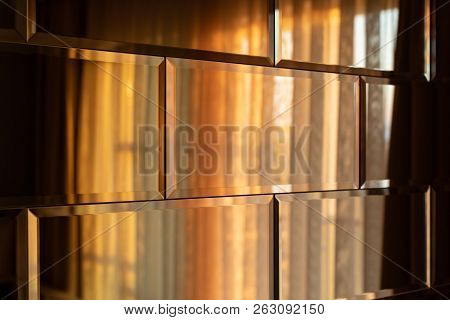 The Surface Of The Mirror Tiles. Wall Of Mirrored Tiles With Edges. Interior Design With Sunset Ligh