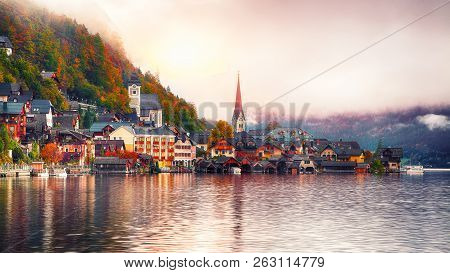 Scenic View Of Famous Hallstatt Mountain Village With Hallstatter Lake. Foggy Autumn Sunrise On Hall